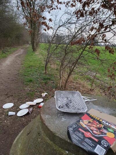 Bild vergr&ouml;&szlig;ern: Auf dem Spazierweg zwischen Friedrichsruher Weg und Langenst&uuml;ckenweg wurden am Samstag, 9. M&auml;rz, Hinterlassenschaften eines Grillfestes gefunden. Einmalgrill, Pappteller, Alufolie, Plastikbesteck, Verpackungsmaterial von Grillfleisch, Geb&auml;ck und Schokoriegeln flogen unsch&ouml;n in der Natur umher